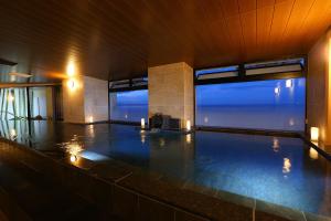 einen Pool mit zwei großen Fenstern und einem Pool in der Unterkunft Ooedo Onsen Monogatari Beppu Seifu in Beppu