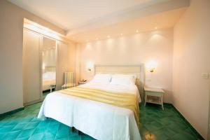 a bedroom with a large bed with a yellow and white blanket at Hotel Continental Ischia in Ischia