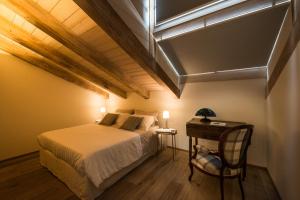 a bedroom with a bed and a table with a chair at Il Riposo del Gladiatore in Aosta