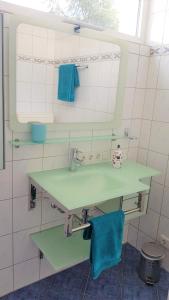 uma casa de banho com 2 lavatórios verdes e um espelho em Apartment Am Paradies - 10 Minuten Fußweg zur Innenstadt em Limburg an der Lahn