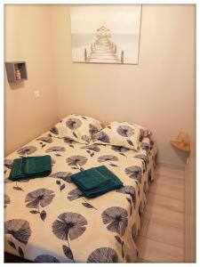 a bed with two pillows on it in a room at -CAPCIR- Standing, cosy, 50m de la plage, parking, wifi in Canet-en-Roussillon