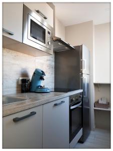 a kitchen with a mixer on a counter with a microwave at -CAPCIR- Standing, cosy, 50m de la plage, parking, wifi in Canet-en-Roussillon