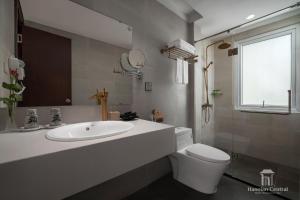 een badkamer met een wastafel, een toilet en een raam bij Hanoian Central Hotel & Spa in Hanoi