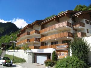 a large building with wooden balconies on it at CRYSTAL 25 - Duplex centre village et proche pistes, vue montagnes - Garage in La Clusaz