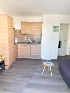 a living room with a blue couch and a kitchen at Les Jardins Du Golf – Mandelieu in Mandelieu-la-Napoule