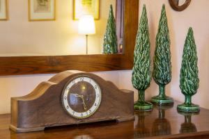 a clock sitting on a table next to two plants at Villa Mocarello in Poggibonsi