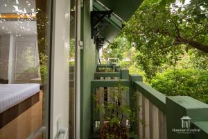 a green house with a porch with stairs at Hanoian Central Hotel & Spa in Hanoi