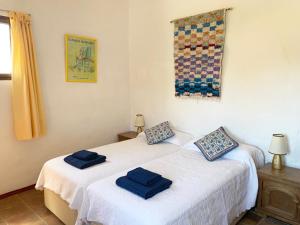 two beds in a room with blue towels on them at La Casilla- La Almona Chica in El Chorro +49 photos
