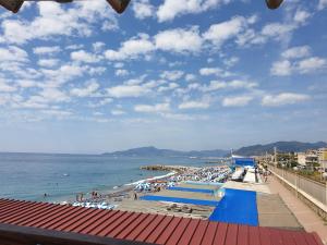 a beach with umbrellas and people on the water at lake house in Mezzanego