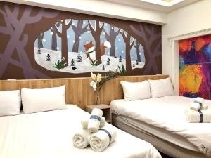 Kaohsiung Time's في كاوشيونغ: سريرين في غرفة مع لوحة على الحائط