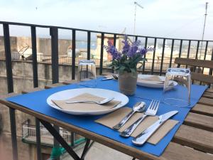 シラクーサにあるCasa dei Réの青いテーブル(皿、銀製品付)が備わるバルコニー