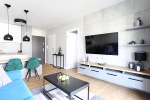 Televízia a/alebo spoločenská miestnosť v ubytovaní Apartament Gardenia Sea&Sun DZIWNÓW PRZY PLAŻY