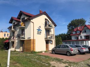 a building with cars parked in front of it at KEJB Chałupy in Chałupy