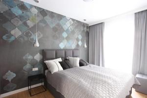 sypialnia z łóżkiem z szarą ścianą w obiekcie Apartament Gardenia Sea&Sun DZIWNÓW PRZY PLAŻY w Dziwnowie