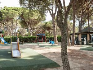 un parque con un parque infantil con un tobogán y un árbol en Studio 4 personnes, climatisé, rez de jardin, en Saint-Raphaël