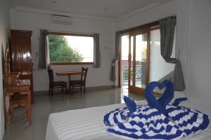 a bedroom with a bed with a blue towel on it at Karma Amed Guesthouse in Amed