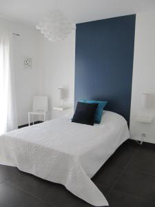 T2 de standing idéalement situé في بروبريانو: غرفة نوم بسرير ابيض كبير بجدار ازرق