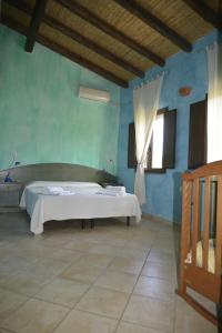 niebieski pokój z łóżkiem i oknem w obiekcie Agriturismo Rubinu w mieście Galtellì