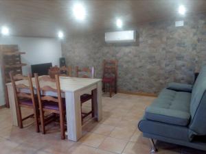 - un salon avec une table, des chaises et un canapé dans l'établissement Apartament turístic Cal Mases , Camarasa, à Camarasa