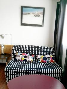 eine schwarz-weiße Couch mit Kissen in einem Zimmer in der Unterkunft Charenton Home in Charenton-le-Pont