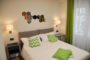 a bedroom with a bed with green curtains and a window at EVA LUXURY ROOMS CAGLIARI in Cagliari