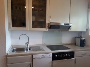 a kitchen with a sink and a stove and cabinets at Apartment Steinsgård-Maura in Maura