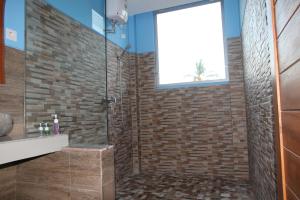 a bathroom with a glass shower with a sink at Karma Amed Guesthouse in Amed