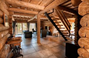 a large living room with wooden ceilings and a staircase at WOODS LODGE PLITVICE LAKES in Drežnik Grad