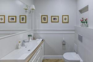 a white bathroom with a sink and a toilet at Avenue in Šiauliai