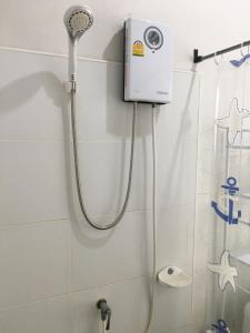 a shower head in a bathroom with a shower curtain at Nava Tara Resort in Takua Pa