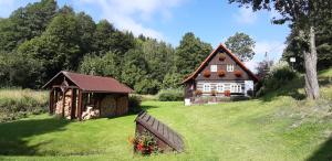 une maison sur une colline avec une clôture devant elle dans l'établissement Chalupa U Studánky, à Adršpach