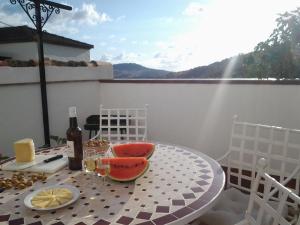 einen Tisch mit einer Flasche Wein und Obst auf dem Balkon in der Unterkunft CASA MARIA LUISA in El Bosque