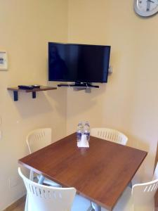 a dining room table with chairs and a television on the wall at Case Vacanze Ancora in Porto Empedocle