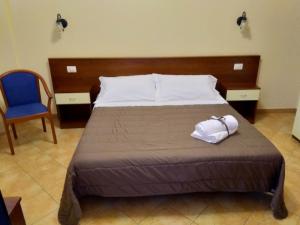 a bedroom with a bed and a blue chair at Case Vacanze Ancora in Porto Empedocle