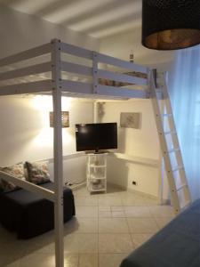 ein Schlafzimmer mit einem Etagenbett, einem TV und einer Leiter in der Unterkunft Blue sea in Aci Castello