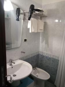 ein Badezimmer mit einem weißen Waschbecken und einem WC in der Unterkunft Blue sea in Aci Castello