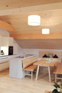 a kitchen with wooden ceilings and a wooden table at Appartments Christine in Bizau