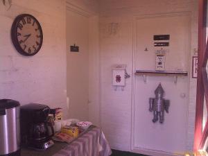 Zimmer mit einer Uhr an der Wand und einer Tür in der Unterkunft Ranch Motel in Tehachapi