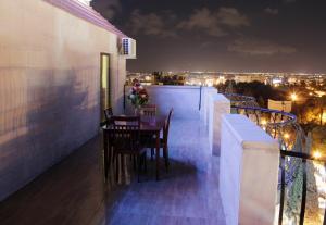 Un balcón con sillas y una mesa con vistas. en Nahas Plaza en Irbid