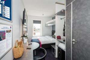 a small room with a bed and a desk at Cabinn Copenhagen in Copenhagen