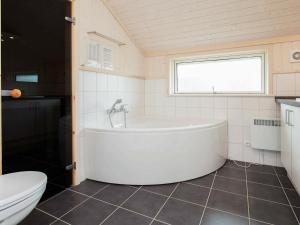 y baño con aseo y bañera blanca. en 8 person holiday home in Gro enbrode, en Großenbrode