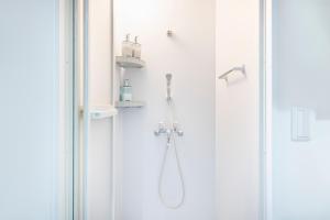 a shower with a shower head in a bathroom at Uhome Ueno Apartment 4 in Tokyo +25 photos