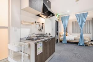 a kitchen with a sink and a room with a bed at Uhome Ueno Apartment 4 in Tokyo