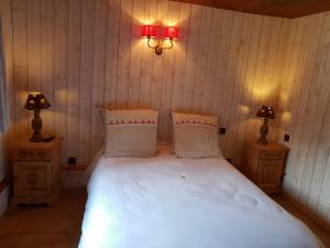 Un dormitorio con una cama blanca con dos lámparas. en Grand Chalet Du Lac Du Boreon, en Saint-Martin-Vésubie
