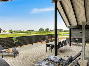 d'une terrasse avec une table et des chaises et une vue sur un champ. dans l'établissement 14 person holiday home in Bogense, à Bogense
