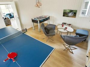 a room with a ping pong table with chairs and a chessboard at 18 person holiday home in Liseleje in Liseleje