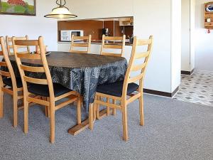 a dining room table with chairs and a kitchen at 6 person holiday home in Hvide Sande in Hvide Sande