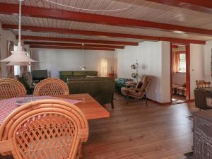 12 person holiday home in L s في Læsø: غرفة معيشة مع طاولة وكراسي