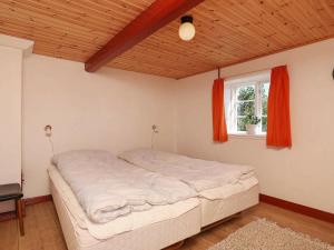 a large bed in a room with a window at 12 person holiday home in L s in Læsø