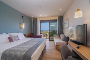 a hotel room with a large bed and a television at Apollonion Asterias Resort and Spa in Xi